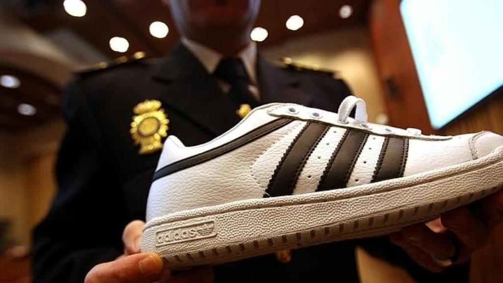 Un policía muestra una zapatilla adquirida ilegalmente por Internet.