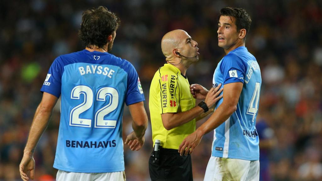 Los jugadores del Málaga protestan al árbitro.