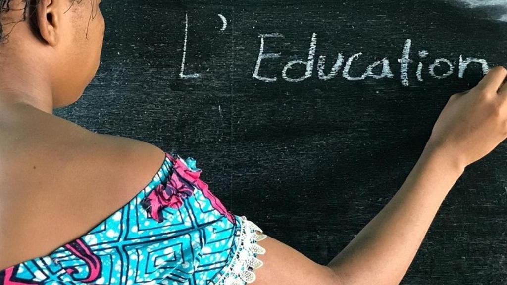 Una niña escribe en la pizarra.