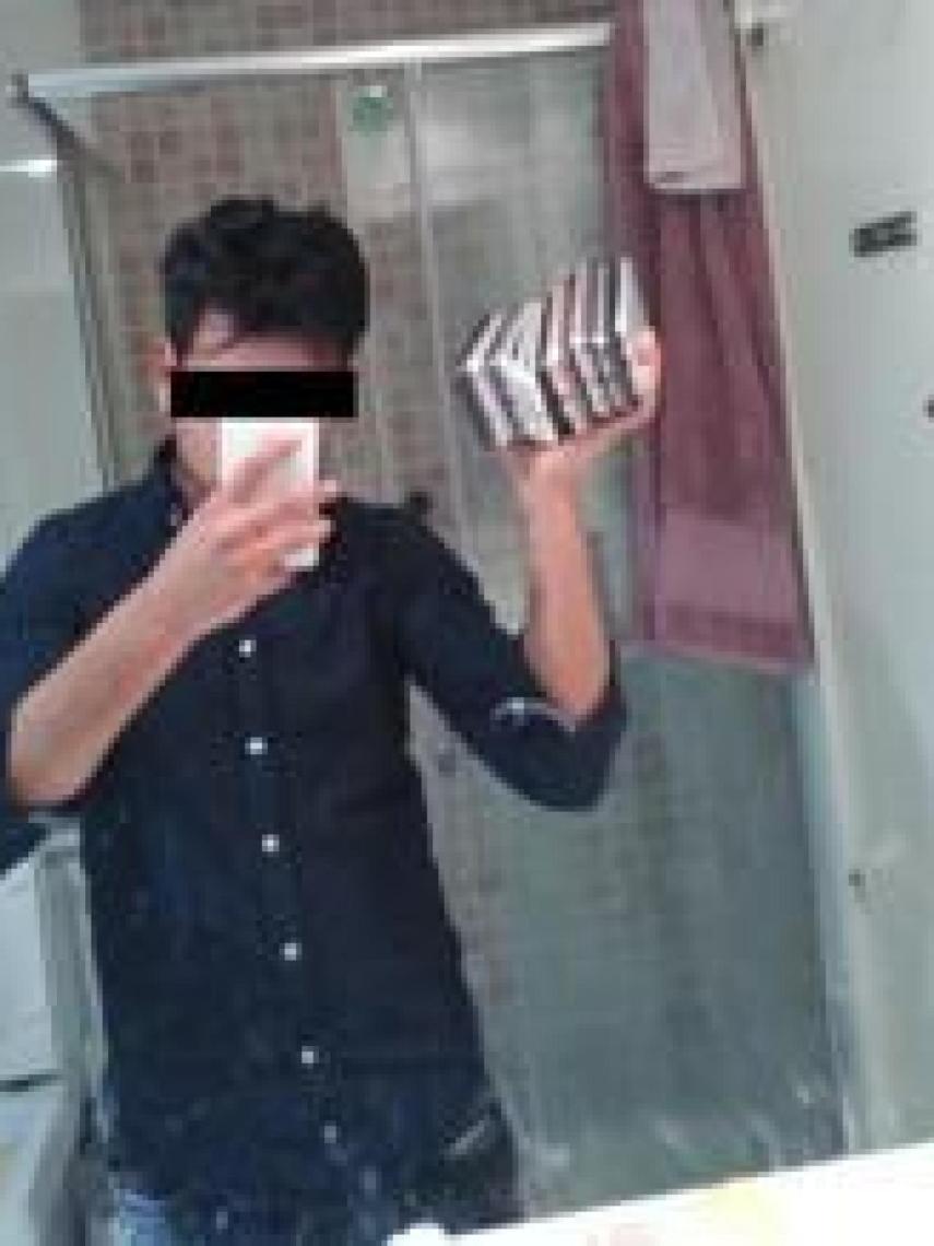 Uno de los miembros del clan se hace una foto con teléfonos robados.