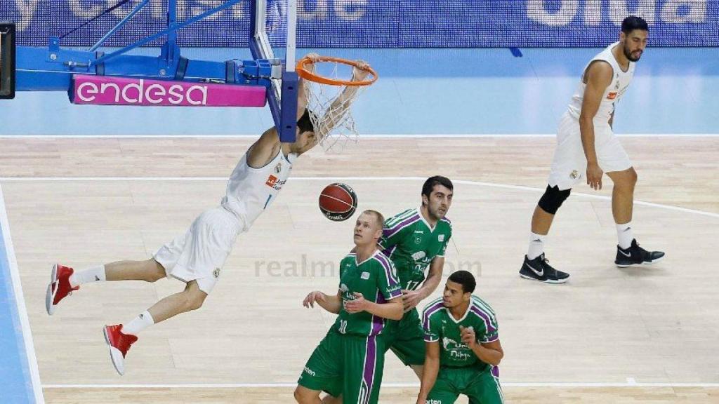 Santiago Yusta anota un mate ante la mirada de los jugadores del Unicaja.