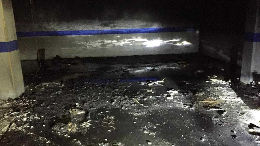 Así quedó la plaza de parking donde estalló la bomba. La deflagración destrozó a coche y propietario.