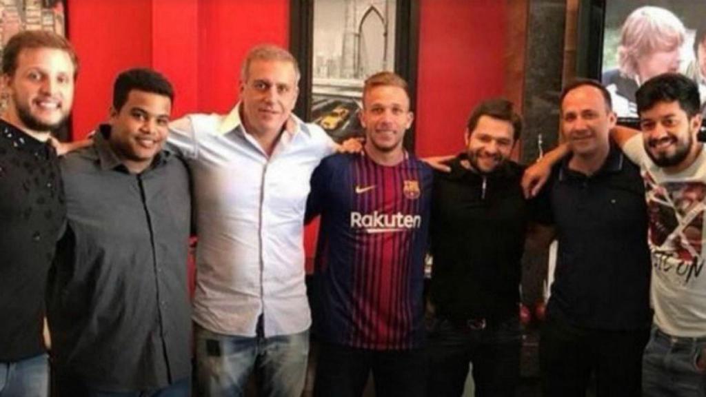 Arthur posando con la camiseta del Barça junto a varias personas, entre ellas el cazatalentos del Barça. Foto: Globesporte