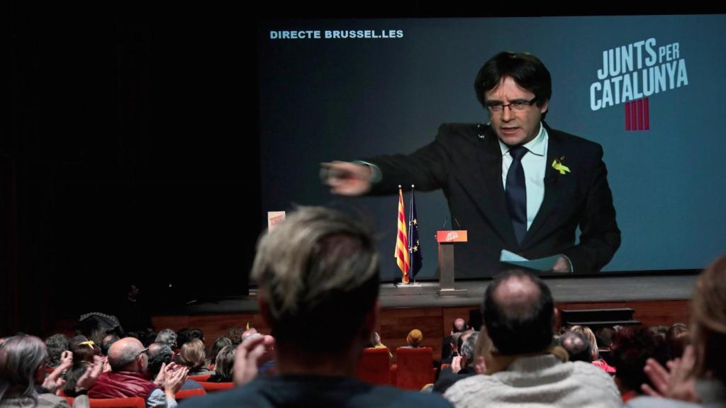 Carles Puigdemont inverviene vía plasma en un acto electoral de su candidatura.