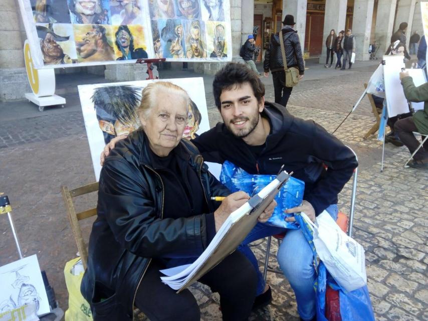 Un voluntario entrega un regalo en la Plaza Mayor.