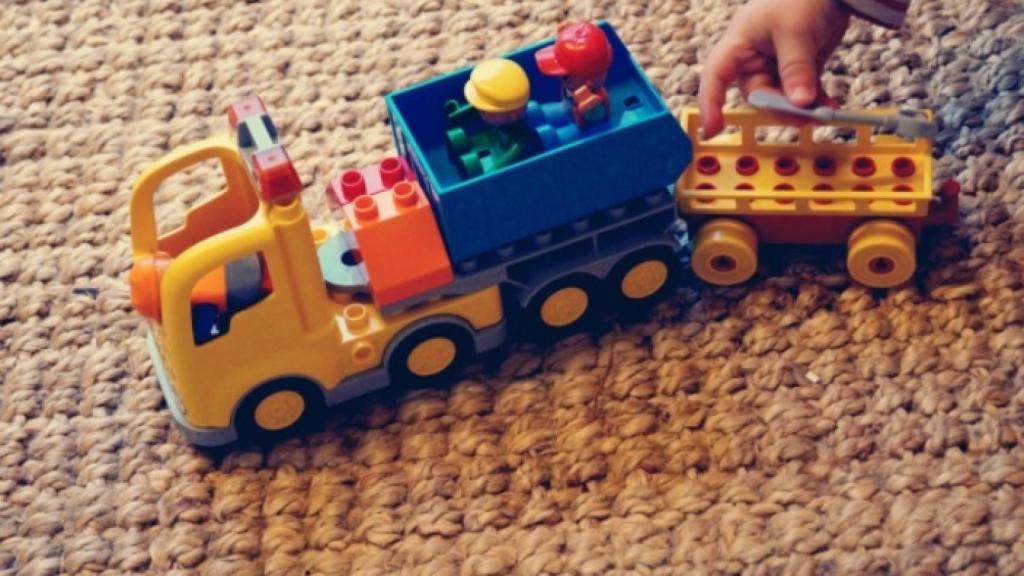 Un niño juega con un camión de juguete.