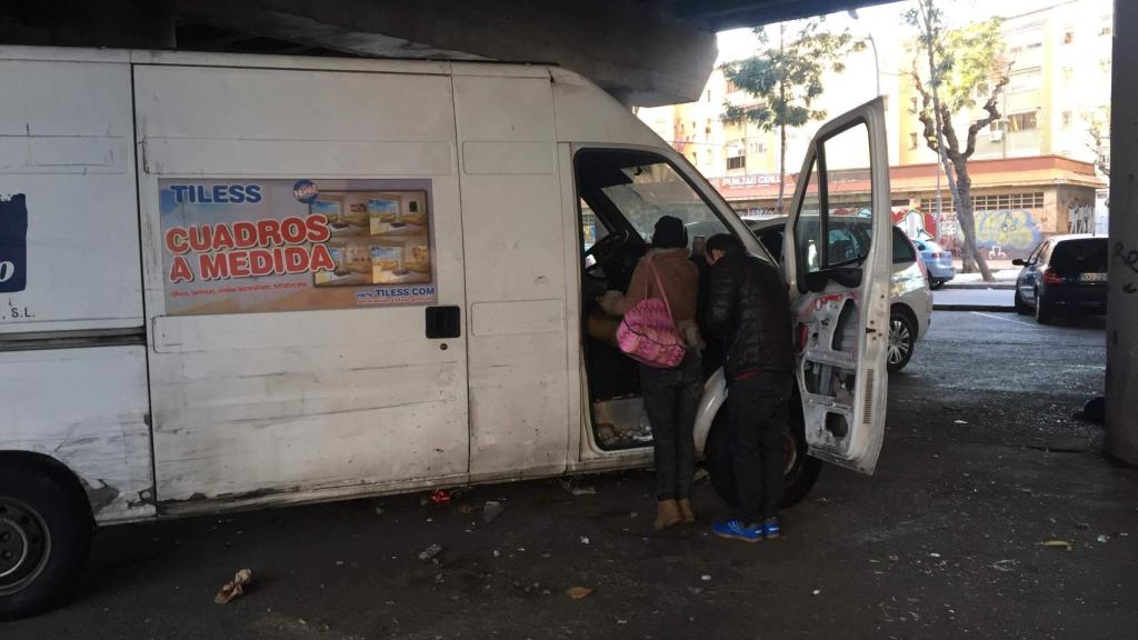 Dos toxicómanos adecentan la furgoneta abandonada antes de ponerse, bajo el puente de la autopista en Badalona