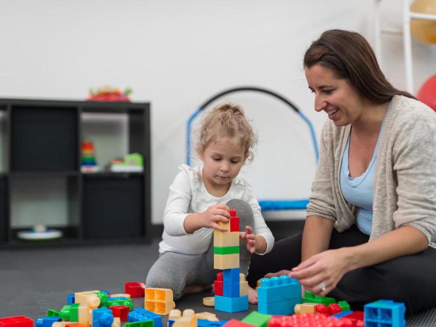 Un niño y su terapeuta durante una sesión de atención temprana.