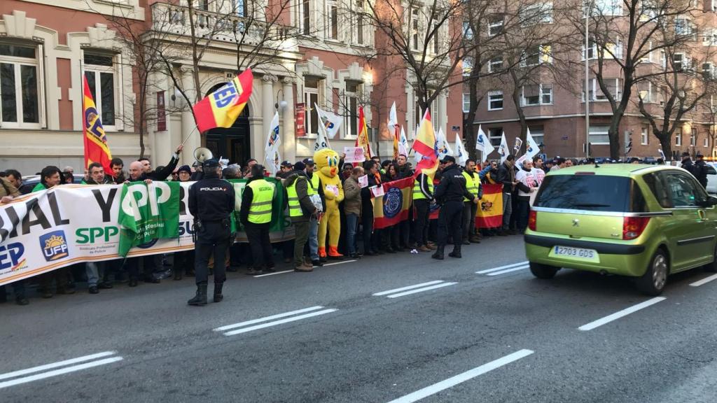 Agentes en la calle aguardan mientras se celebra la reunión.