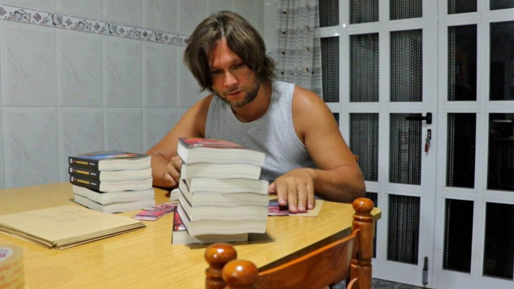 Rafael Fernández en su casa junto a una torre de vídeos.