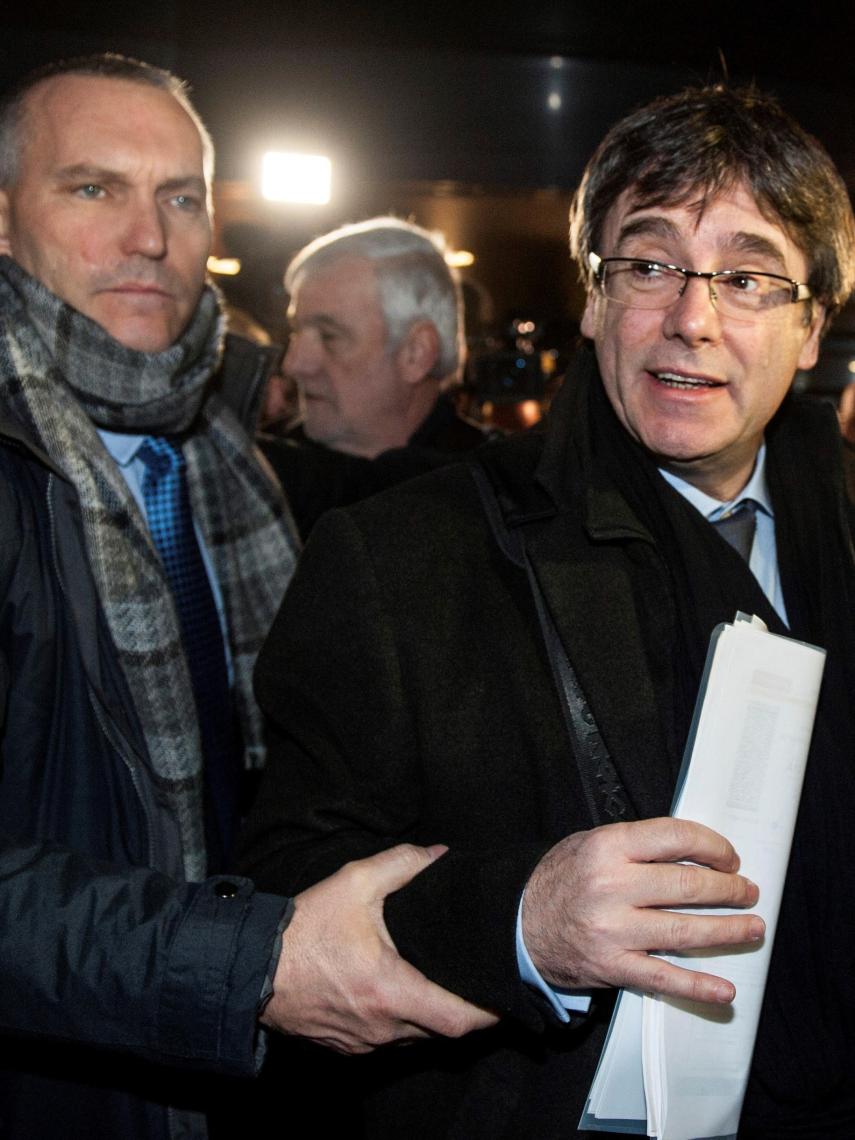 Lluís Escola protege a Puigdemont en su viaje por Europa.