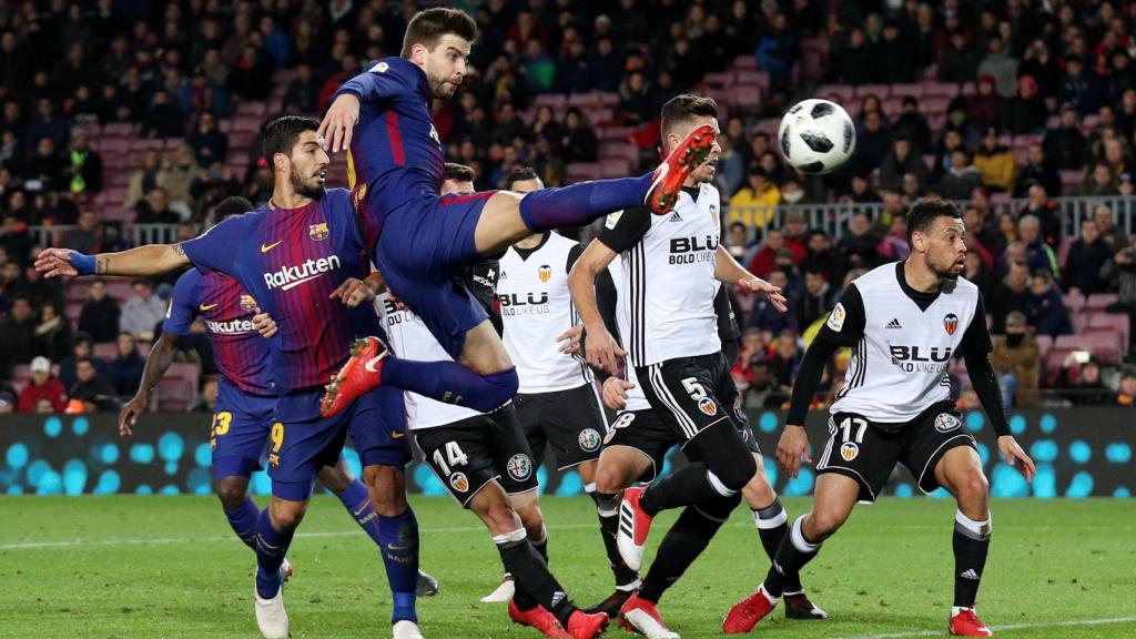 Piqué trata de meter la pelota en el área.
