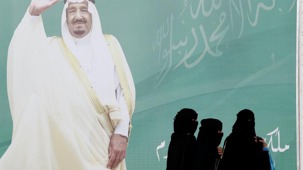 Varias mujeres pasan por delante de un cartel en Riad.