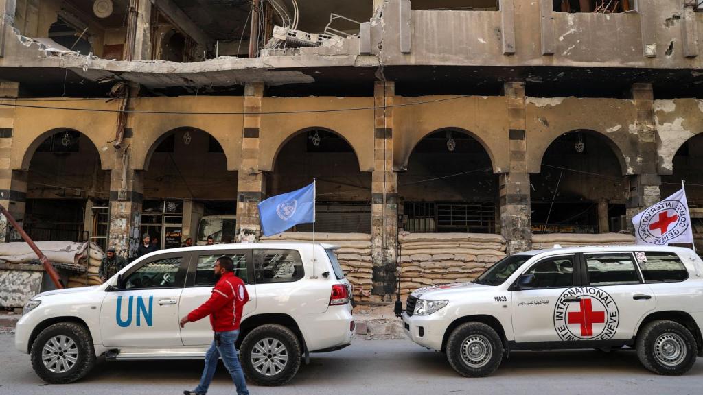 Dos coches de la ONU y del Comité Internacional de la Cruz Roja, durante la llegada de un convoy humanitario a  Duma.