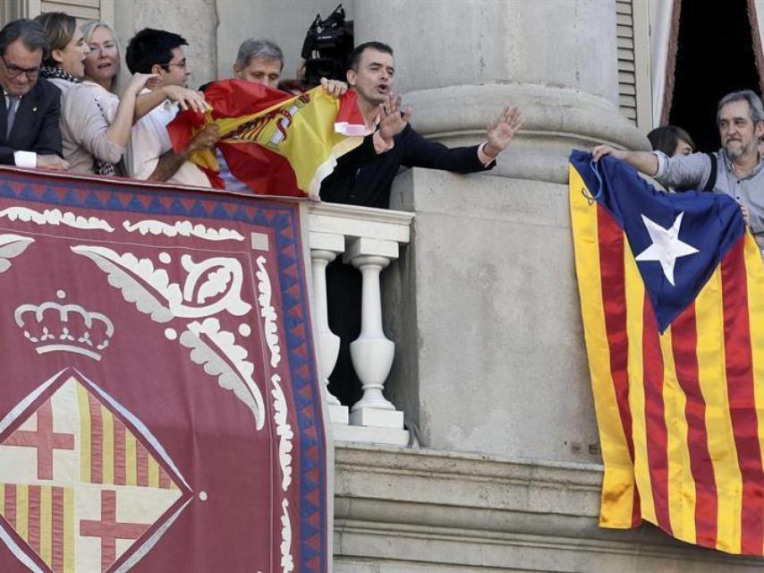 Gerardo Pisarello intenta arrancarle una bandera española de las manos a Alberto Fernández, del PP.