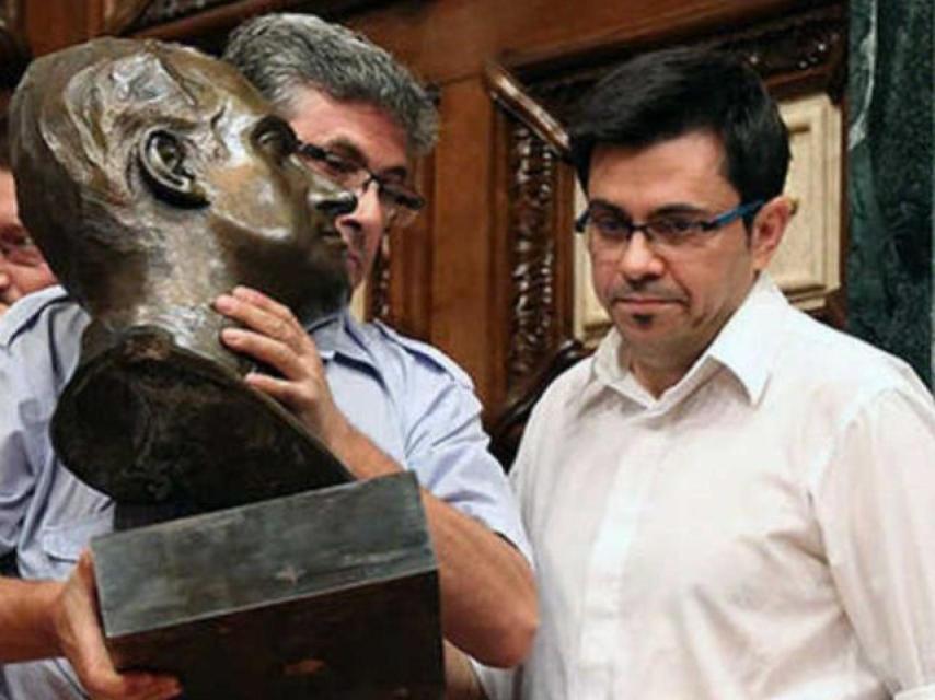 Los operarios del ayuntamiento retiran el busto del rey Juan Carlos, vigilados por Pisarello.