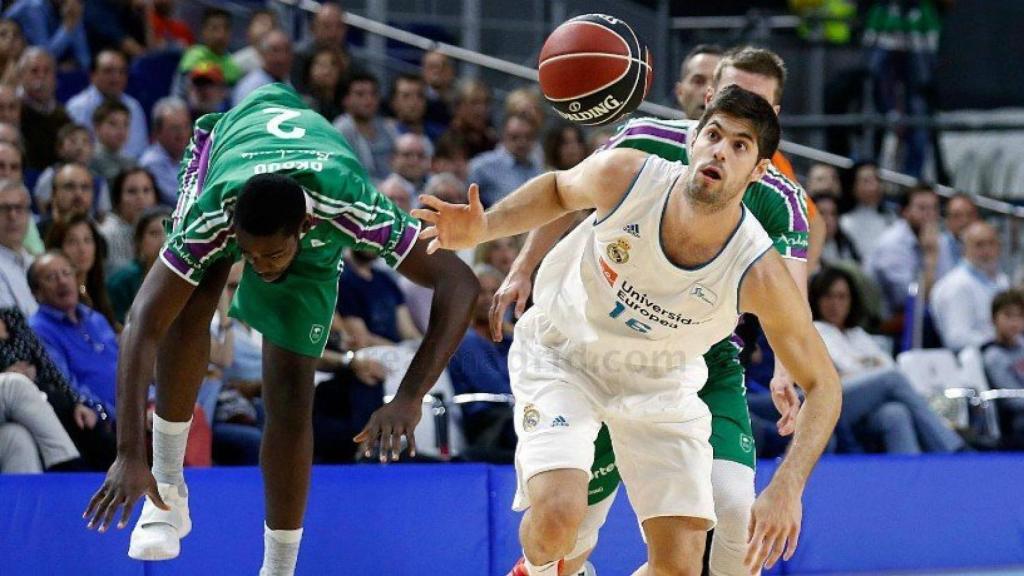 Santiago Yusta disputando un balón con los jugadores del Unicaja.
