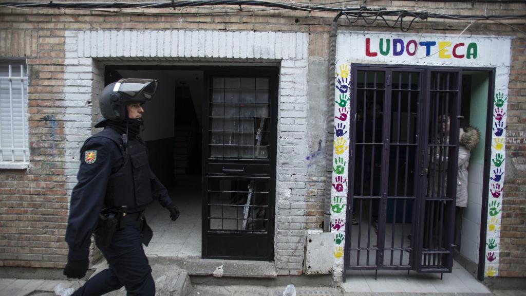 Un agente de la UIP pasa por delante de una ludoteca del barrio de Almanjáyar.