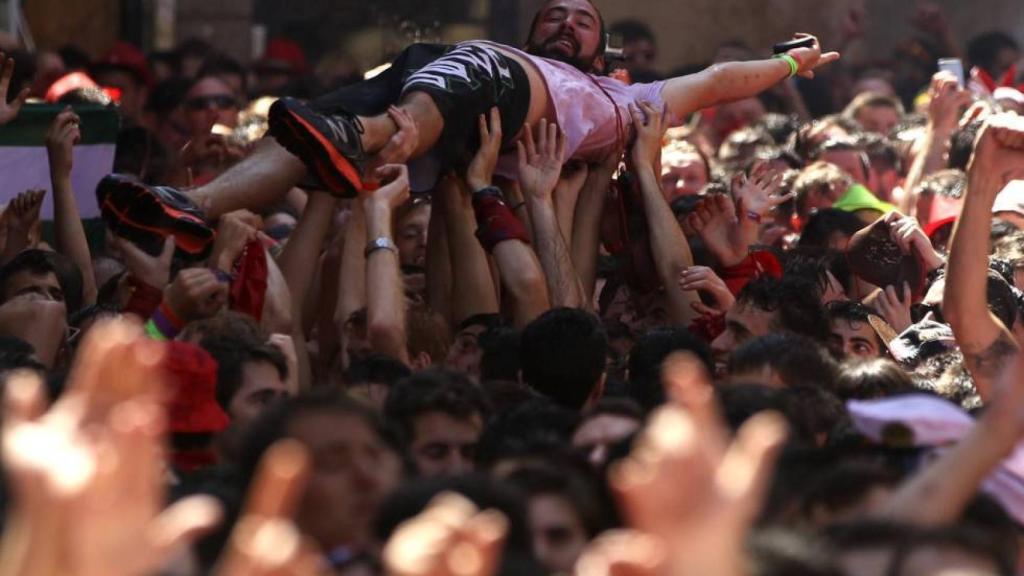 Un joven llevado en volandas en sanfermines.