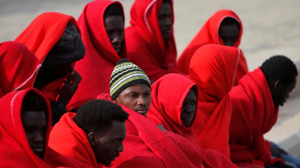 Un grupo de migrantes descansan en el puerto de Málaga tras ser rescatados