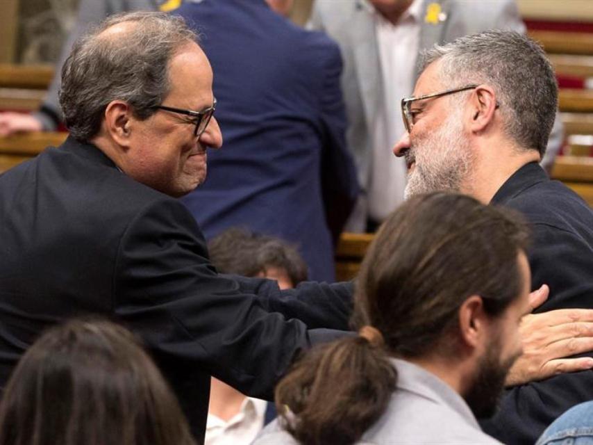 Quim Torra saluda al diputado de la CUP Carles Riera en el Parlamento de Cataluña el pasado sábado.