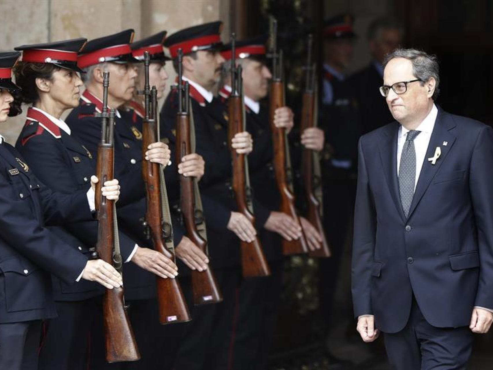 El nuevo presidente de la Generalidad, Quim Torra, sale del Parlament ante la formación de gala de los Mossos.