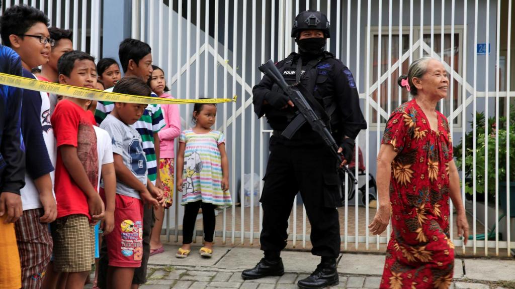 Un agente antiterrorista hace guardia frente a la casa de un presunto terrorista.