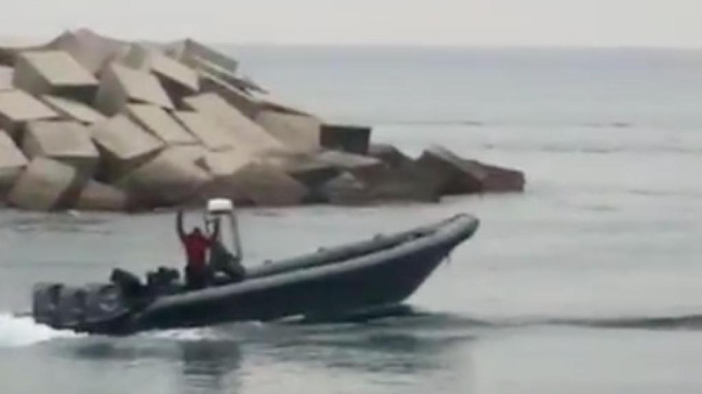 Un ocupante de la narcolancha saluda y manda besos a la Policía Nacional tras descargar el hachís