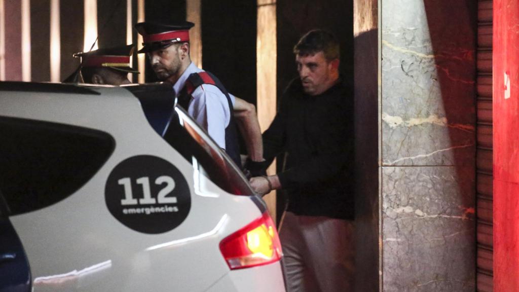 Joan López, a punto de ser introducido en el coche policial de los Mossos