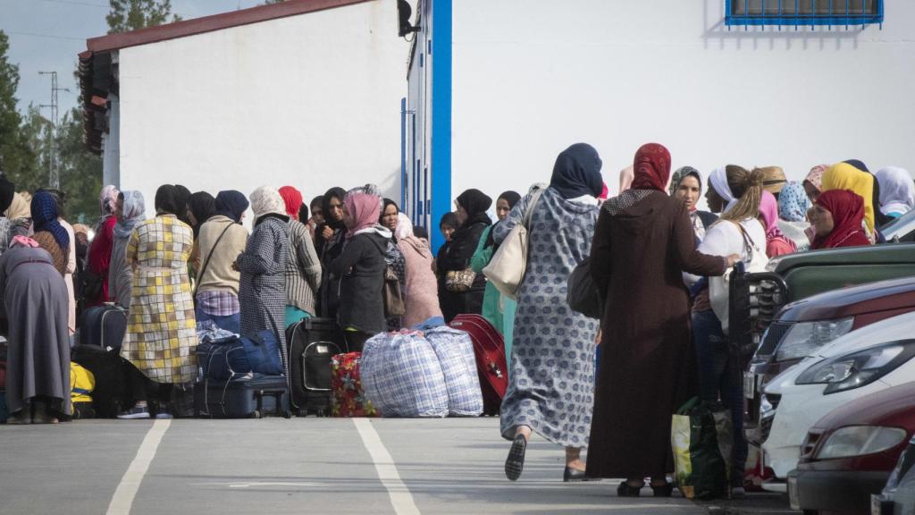 Grupo de jornaleras esperando la salida del autobús que las conducirá desde las fincas de Huelva hasta el puerto de Tarifa (Cádiz) para subirse al ferry con destino a Tánger (Marruecos).