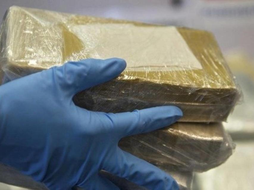 Un agente sostiene varios paquetes incautados en una operación antidroga.