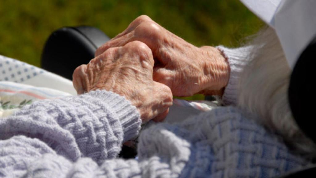 Una enferma de alzhéimer entrelaza sus manos.
