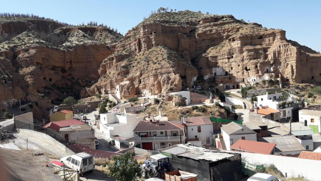 La casa-cueva de Juan Heredia 'el Canuto', donde vive con su prole, a la izquierda de la foto. A la derecha, algunos de sus vehículos (2)