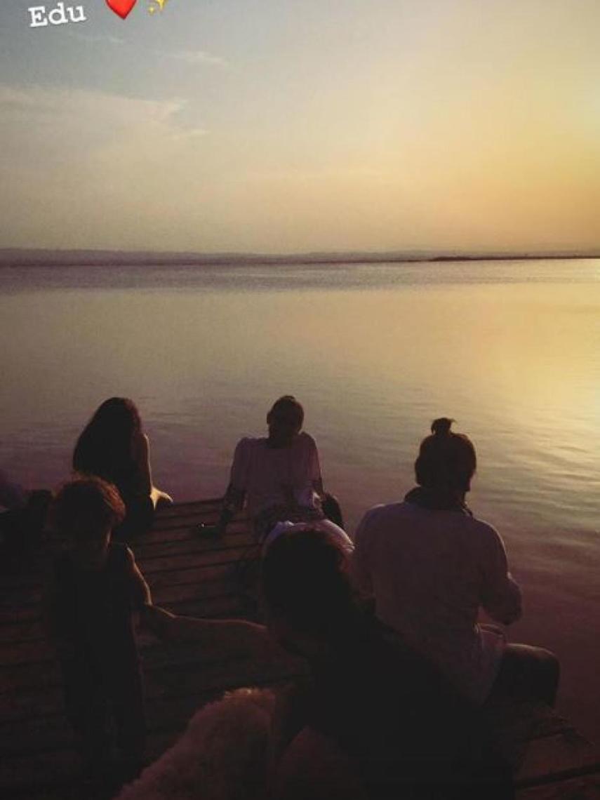 La familia mira fijamente la puesta de sol en Valencia.
