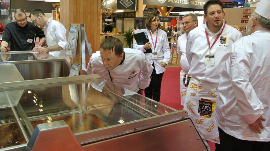 Varios ches se reúnen en torno a una de las máquinas de Metronics en una feria del sector.