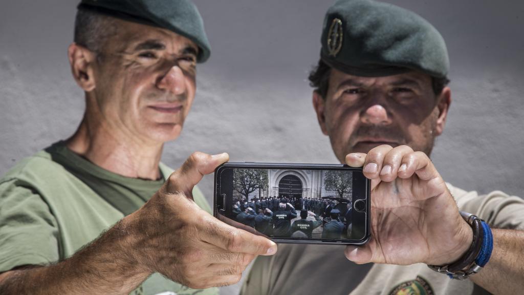 José Luis Serrano ‘el Tigre’ (d) y Francisco Gómez (i), sostienen una imagen del funeral del compañero fallecido, en la que ellos portan el féretro. Foto: Fernando Ruso