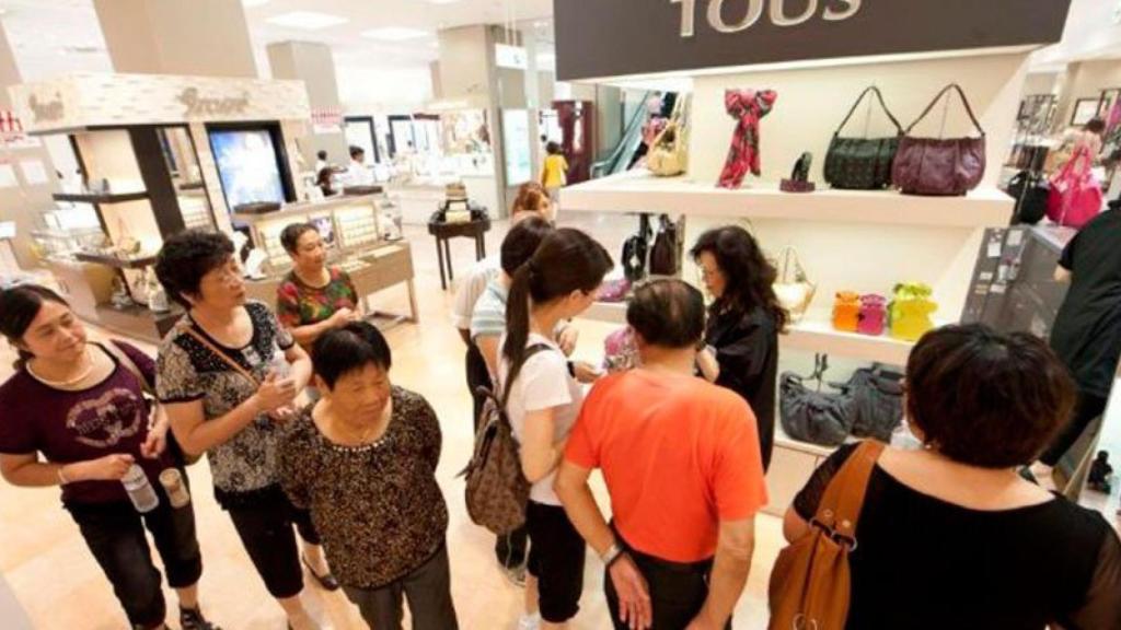 Un grupo de turistas chinos en un comercio de Madrid.