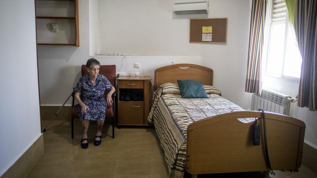 Encarna mirando la cama vacía de su habitación en Alcaracejos (Córdoba). Foto: Fernando Ruso.