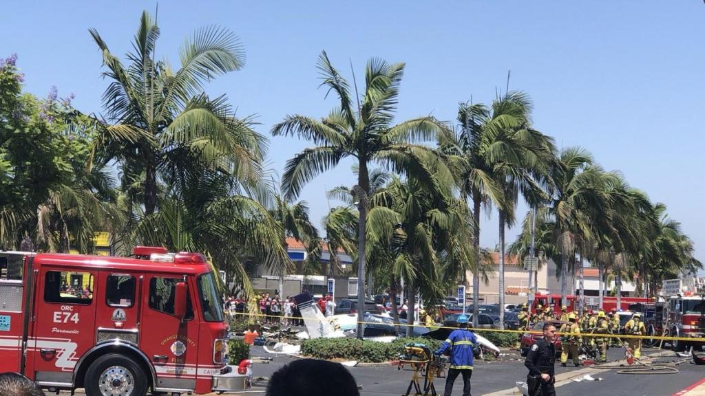 Los bomberos trabajan junto con la avioneta estrellada en un centro comercial de Santa Ana, Los Ángeles.