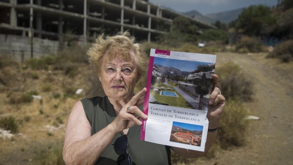 La ciudadana británica Ángela Jhon muestra el dossier que le entregaron al dar la entrada de un apartamento en la promoción Cortijo de Torreblanca. Foto Fernando Ruso