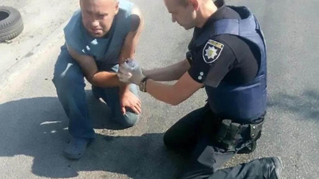 Un agente le ayuda a mantener la presión con cinta americana.