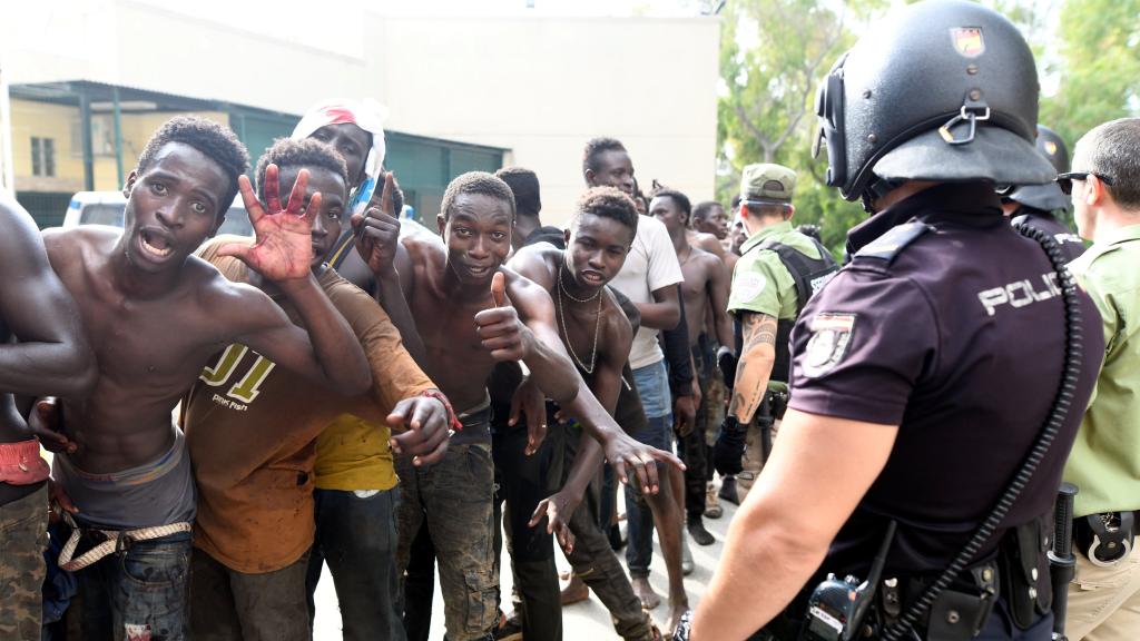 Varios inmigrantes subsaharianos celebran el salto con éxito a la valla de Ceuta.