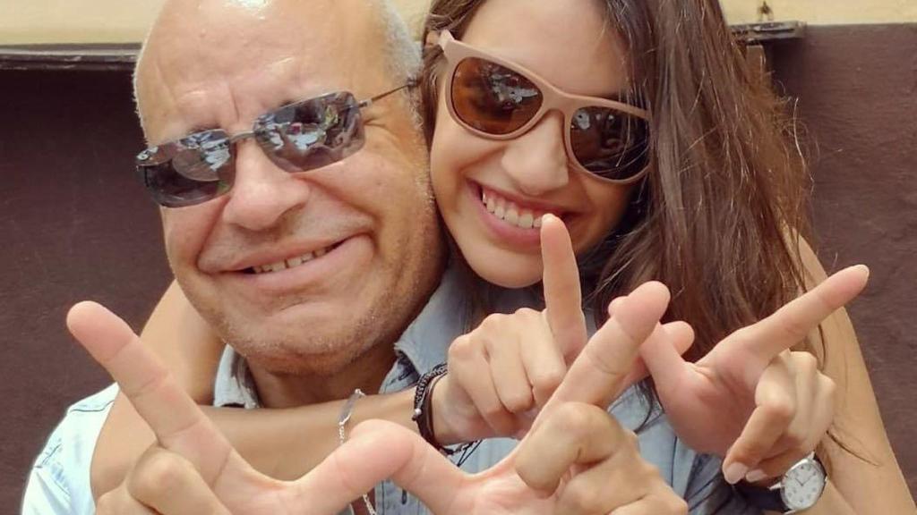 Padre e hija haciendo el signo de la 'W' de War.