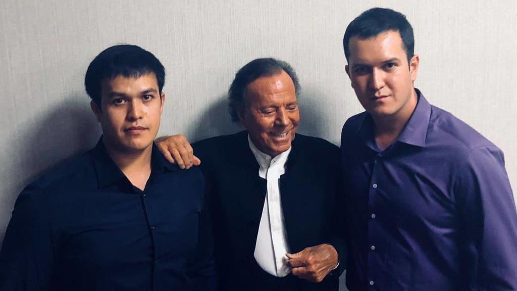 Julio Iglesias, agarrándose a unos fans en Uzbekistán.