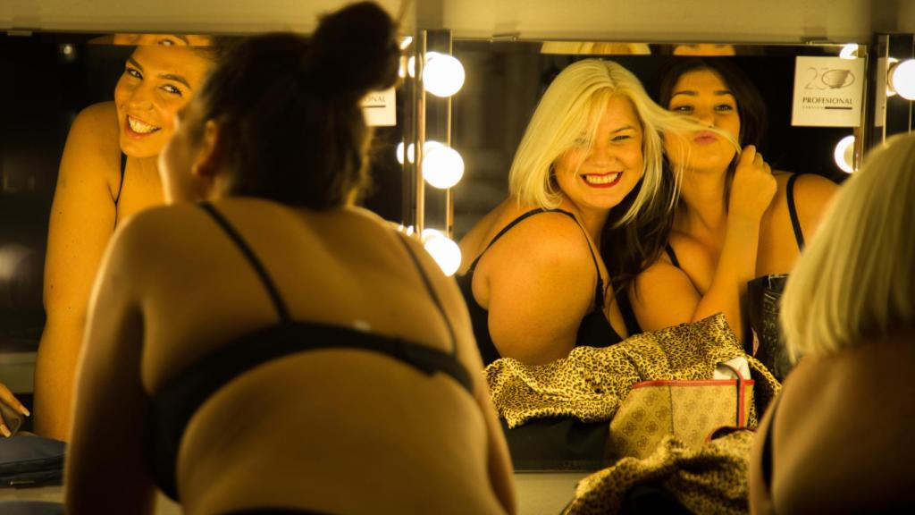 Las modelos se retocan el peinado frente a un espejo de la zona de camerinos.