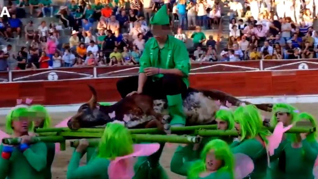 Jóvenes disfrazados de hadas y duendes transportan al novillo moribundo.