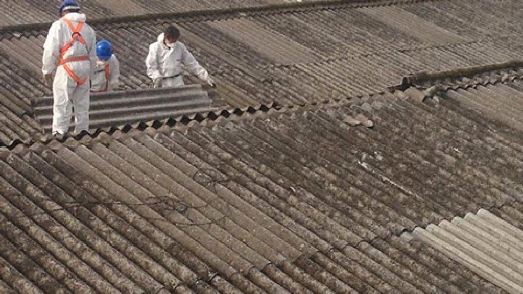 Desde 2002, en España está prohibido el uso de amianto, que solía usarse para techados. En la imagen, dos operarios retirando un tejado de uralita.