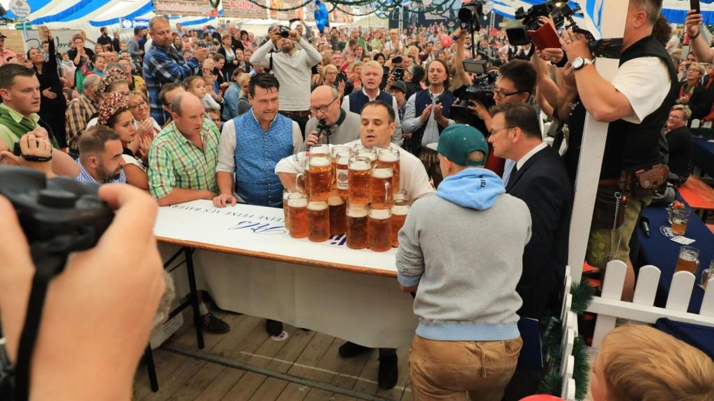 Oliver levanta las jarras de cerveza.