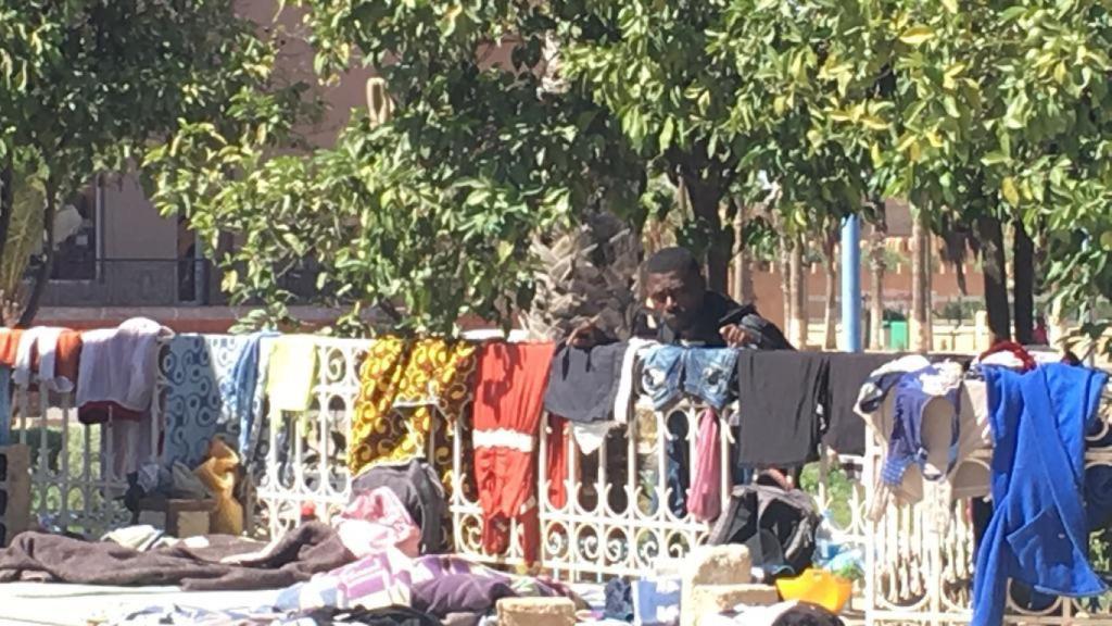 Un migrante aguarda detrás de la valla.