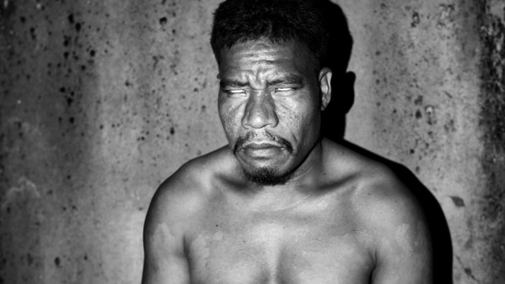 Eric, un habitante de Pingelap, reacciona ante la exposición de la luz eléctrica durante la noche.  (© Sanne de Wilde)